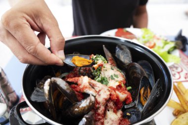 bir adam bazı moules a la bonifacienne, midye Bonifacio, Corsica, Fransa için tipik bir tarifi yeme closeup