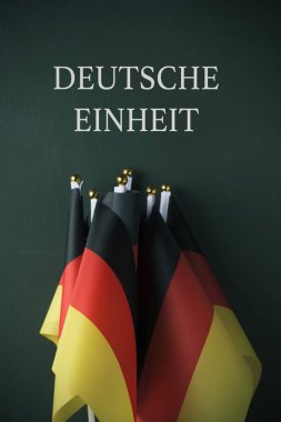 Almanya ve metin Deutsche Einheit, Alman birlik Almanca, koyu yeşil bir arka plan karşı yazılmış bazı bayrakları