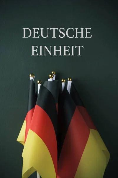 ドイツのテキスト ドイツ Einheit ドイツの統一の濃い緑色の背景に対してドイツ語で書かれたいくつかのフラグ — ストック写真