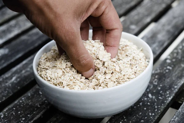 Primer Plano Mano Joven Caucásico Agarrando Avena Enrollada Cuenco Cerámica —  Fotos de Stock