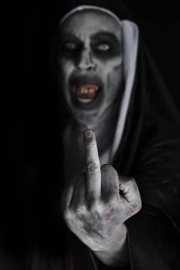 closeup of a frightening evil nun, with bloody teeth and scary eyes, wearing a typical black and white habit, giving the middle finger clipart