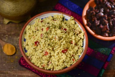 tabbouleh, bir toprak kase görünümünü yüksek açı öğle veya akşam yemeği, altın bir çaydanlık ve güneşte kurutulmuş domates ile bir kase yanındaki ayarla bir tabloda bir tipik Levanten Arap Salatası