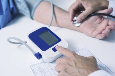 beyaz bir ceket, bir beyaz doktor adam closeup üst düzey bir beyaz hasta adamın kan basıncı tansiyon aleti ile ölçme.