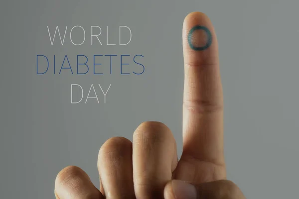 特写镜头一个年轻的白种人与一个蓝色的圈子 糖尿病的象征 在他的食指 和文本世界糖尿病日 — 图库照片