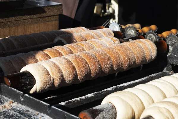 closeup of some trdelnik, a typical spit cake, being baked in a street market stall in the old town of Prague, Czech Republic