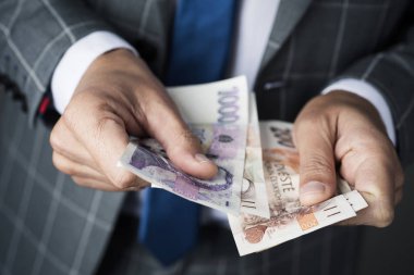 Bazı Çek korunası banknot sayma zarif bir gri takım elbise giymiş bir genç beyaz işadamı, closeup