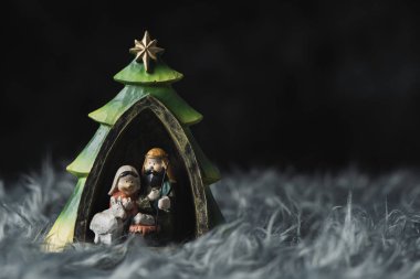 Kutsal Aile, Çocuk İsa, Meryem ve Aziz joseph, bir gri suni kürk, sağda bir boşluk ile karanlık bir arka plan üzerinde
