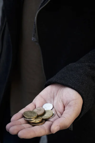 一个年轻的高加索男子在街上的特写镜头与一些捷克科鲁纳硬币在他的手 — 图库照片