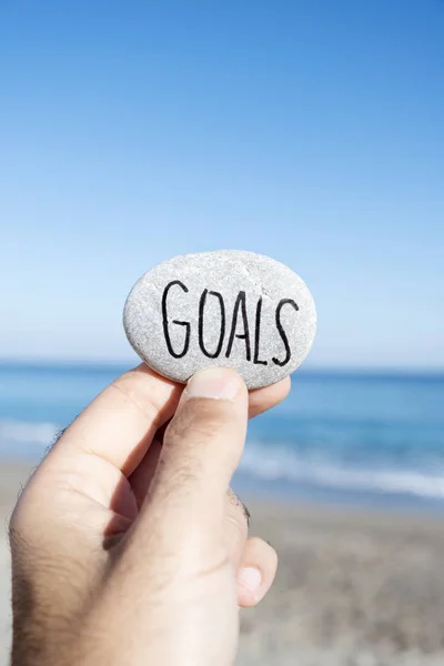 Closeup Young Man Stone His Hand Text Goals Handwritten Beach — Stock Photo, Image