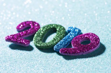Bazı glitter sayılar sayı 2019, yeni yıl, olarak bir mavi parlak arka plan üzerinde oluşturan farklı renkteki closeup