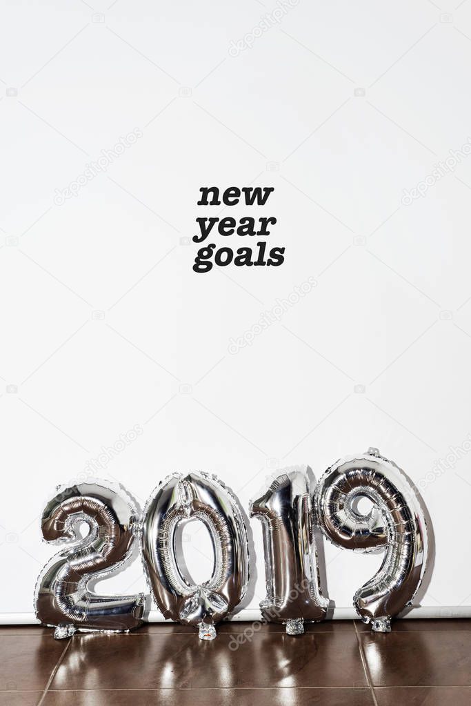 el texto goles de año nuevo y algunos globos plateados en forma de