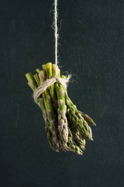 portre bir demet kuşkonmaz bir kenevir dize, koyu bir yeşil arka plan asılı