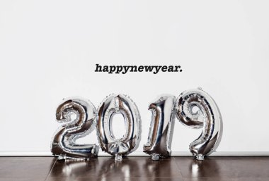 metin happy new year ve beyaz bir arka plan karşı numarası 2019 oluşturan gümüş bazı sayı şeklindeki balonları