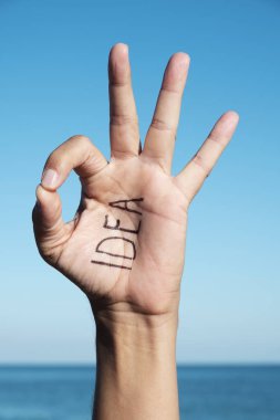 tatlı genç bir beyaz adam açık havada onun, denizin içinde belgili tanımlık geçmiş ile yazılı kelime fikri ile ok jest yapma
