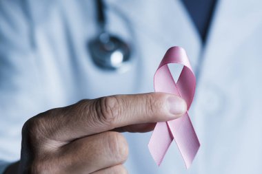 elinde pembe bir kurdele ile beyaz bir ceket giyen bir genç beyaz doktor adam closeup