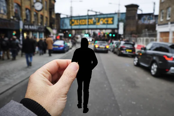 一个白种人手拿着一个年轻人形状的剪纸 头戴头套 走在英国伦敦受欢迎的高坎登街旁边 — 图库照片