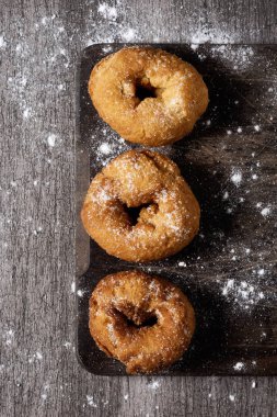 bazı ev yapımı rosquillas, Paskalya, rustik ahşap bir masa üzerinde genellikle yenen İspanyol donuts görüş yüksek açısı ile krema şeker serpilir