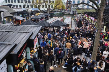 LONDON, UK - DECEMBER 30, 2018: Visitors at Camden Lock. Camden Lock, Camden Market, and streets nearby are the fourth-most popular attraction in the city, attracting 100,000 people each weekend clipart