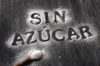 rustik bir gri ahşap masa nereye sen-ebilmek okumak metin ile şeker serpilir görünümünü yüksek açı azucar günah, ücretsiz yazılı İspanyolca ve şeker dolu bir kaşık şeker
