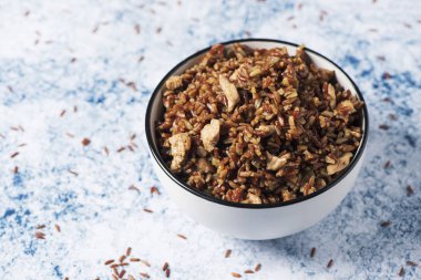 Kızarmış kırmızı pirinç bir mermer tablo veya tezgah doğranmış tavuk eti ile beyaz bir seramik kase closeup