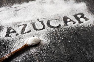rustik bir gri ahşap tablo görünümünü yüksek açı nereye sen-ebilmek okumak sözcük azucar, İspanyolca ve bir kaşık şeker dolu yazılı şeker şeker serpilir