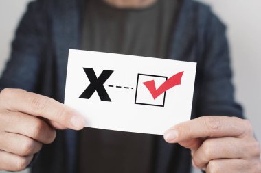 closeup of a young caucasian person holding a piece of paper with a X written in it, for the third gender category clipart