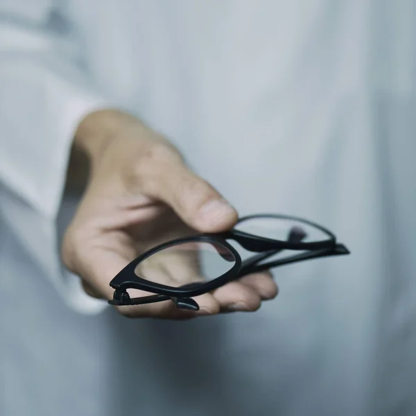 Hombre óptico trayendo un par de anteojos —  Fotos de Stock