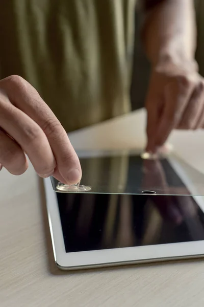 Hombre instalando un protector de pantalla en una tableta — Foto de Stock