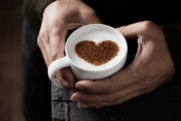 Uomo con una tazza di cappuccino con un cuore — Foto Stock