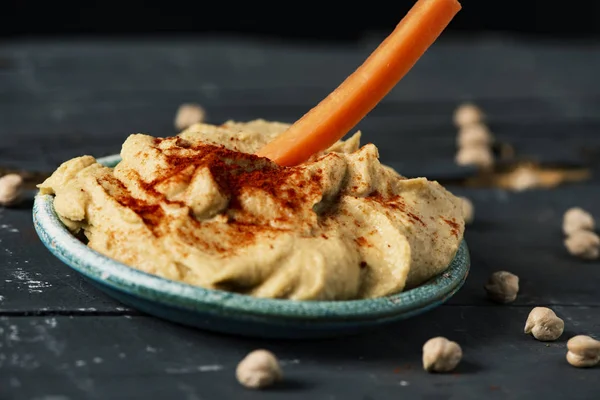 Immergere la carota in un hummus fatto in casa — Foto Stock