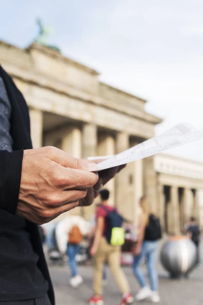 Homme vérifiant une carte à la Porte de Brandebourg, Berlin — Photo