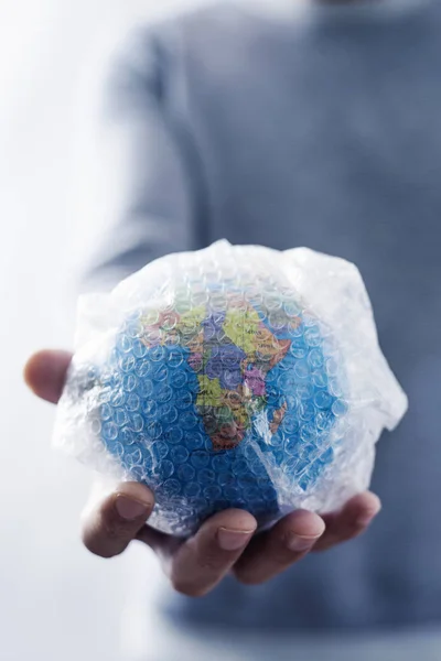 Человек с мировым глобусом, завернутым в пузырь — стоковое фото