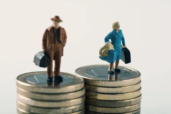 Miniatur-Mann und -Frau auf zwei Stapeln Münzen — Stockfoto