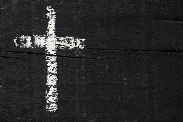 Cruz cristiana sobre una superficie de madera gris oscuro — Foto de Stock