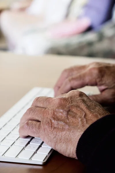Viejo caucásico hombre escribiendo en un teclado — Foto de Stock