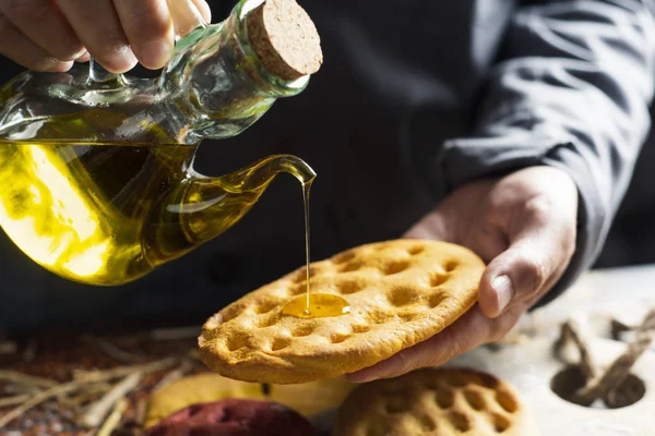 Hombre aderezo con aceite de oliva una focaccia italiana — Foto de Stock