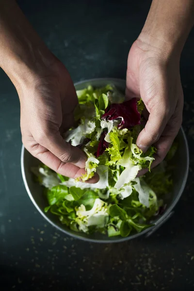 Young caucasian man preparing a salad — Stock Photo, Image