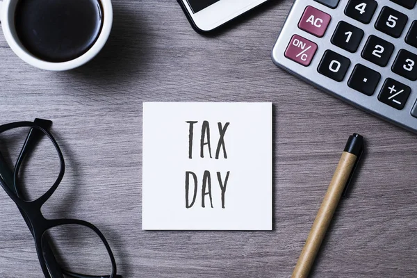 Text tax day in a note on a desk — Stock Photo, Image