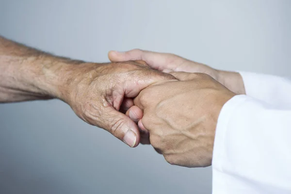 Hombre moviendo la mano de un paciente mayor — Foto de Stock