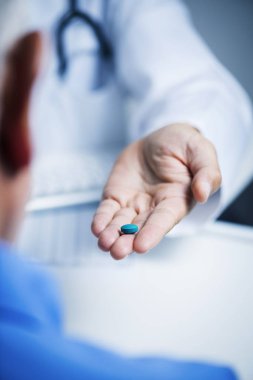 doktor adam yaşlı bir adama mavi bir hap veren