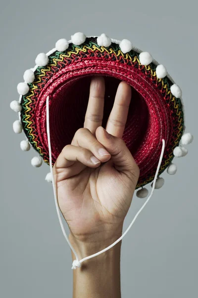 Sombrero mexicano y hombre haciendo el signo V — Foto de Stock