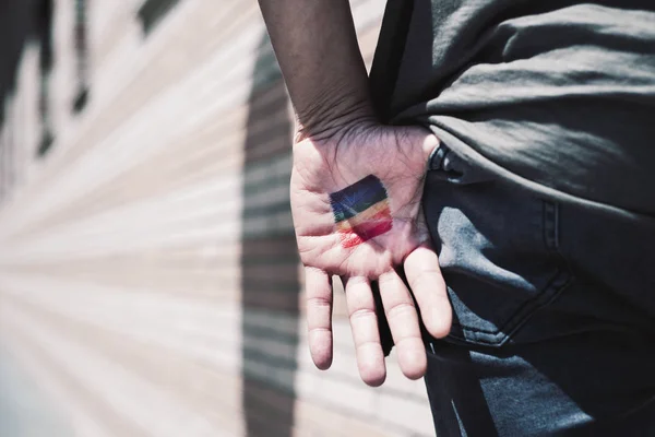 Person with a rainbow flag in his or her hand — Stock Photo, Image