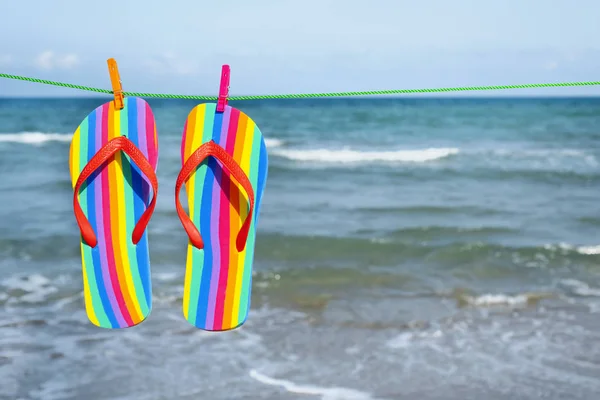 Chinelos de arco-íris pendurados em uma linha de roupas — Fotografia de Stock