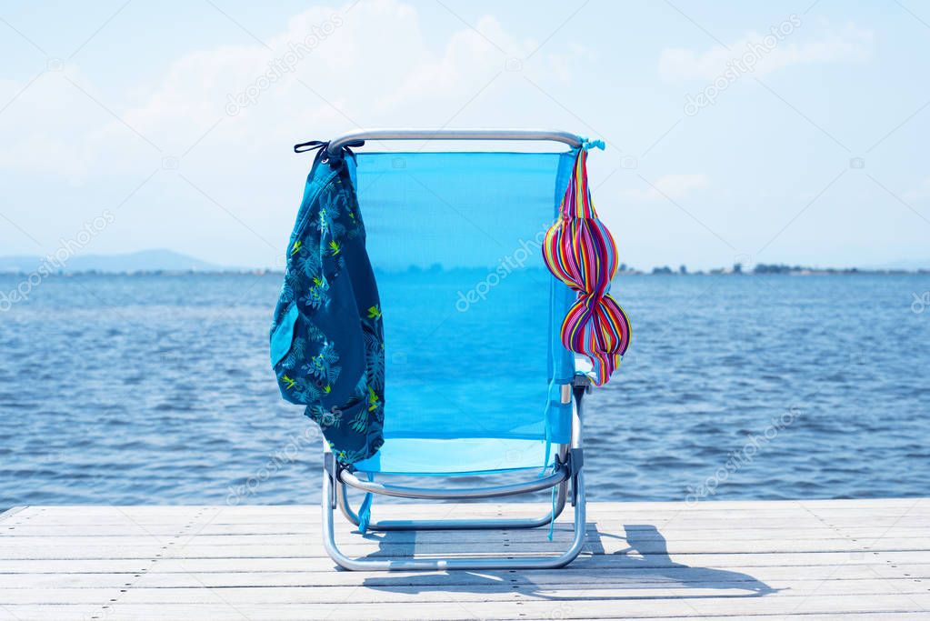 bikini and swimming trunks drying on a pier