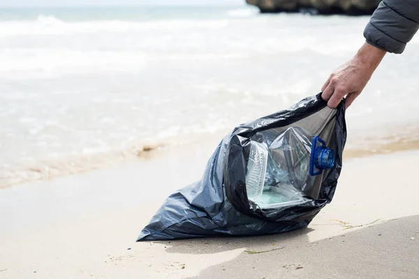 Мужчина и мусор на пляже — стоковое фото