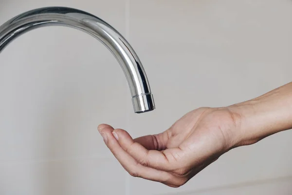 Man waiting for water to come out of a tap — Stock Photo, Image