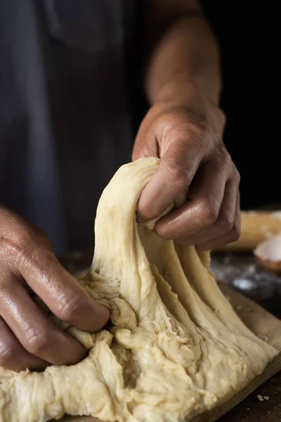 Junger Mann knetet ein Stück Teig — Stockfoto