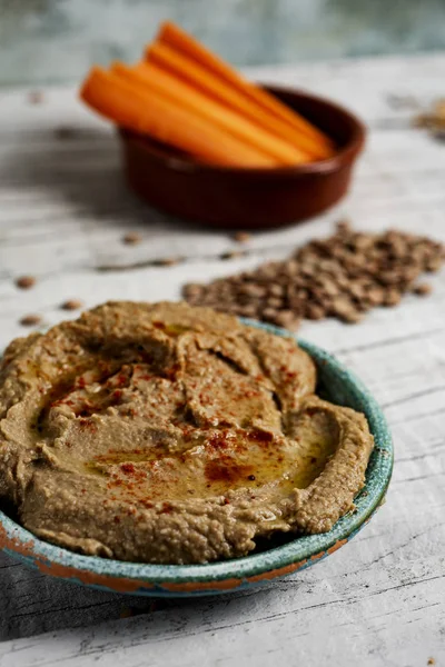 Homemade lentil hummus and strips of carrot — Stock Photo, Image
