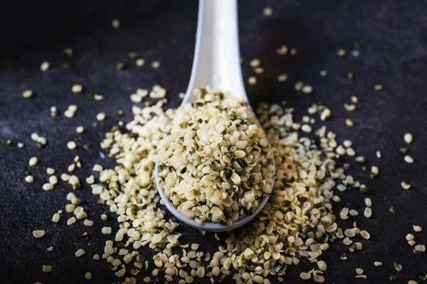 hulled hemp seeds on a dark gray surface