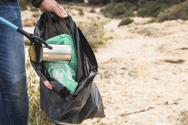 Человек собирает мусор на открытом воздухе — стоковое фото